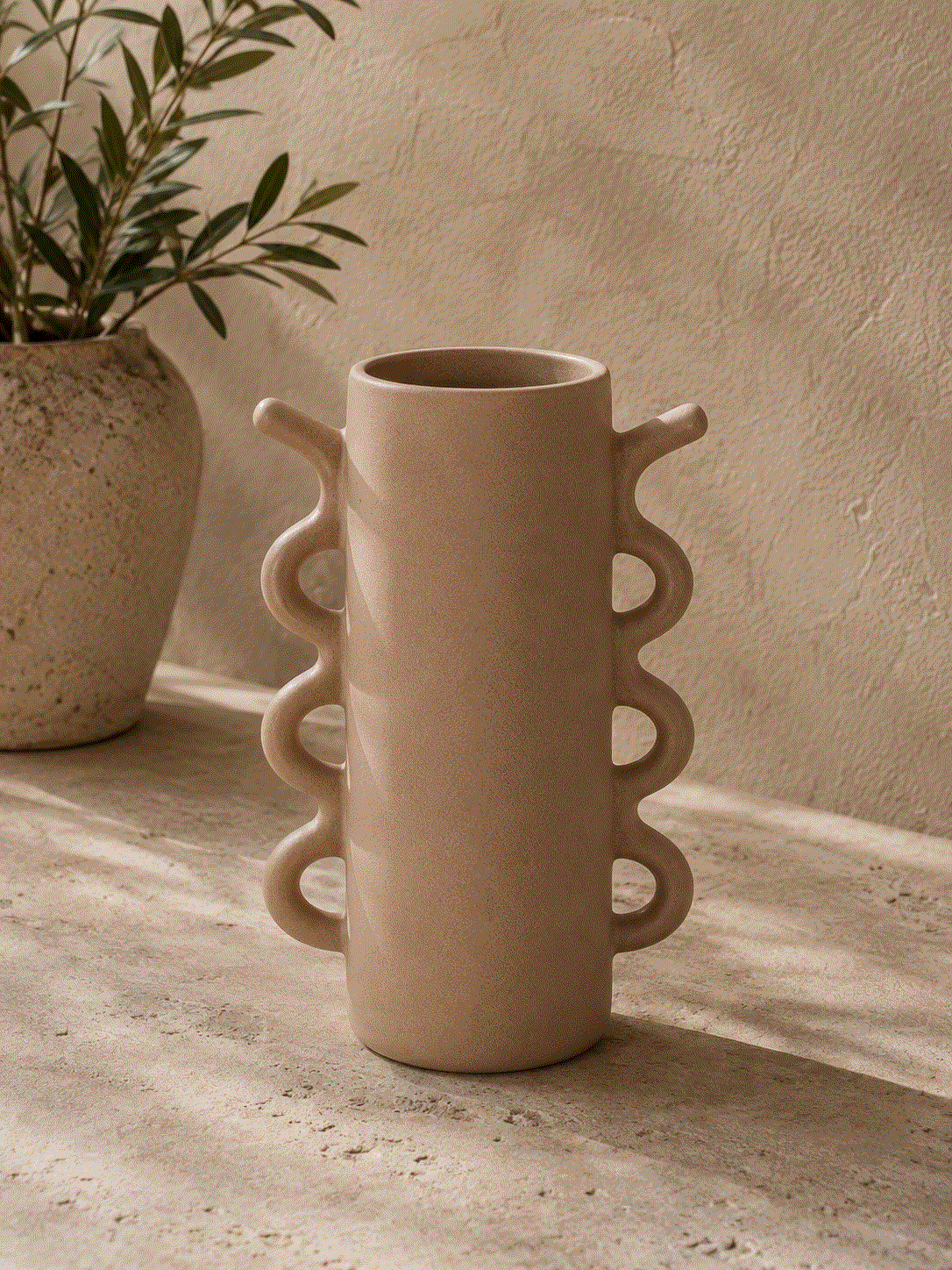Curved Handle Ceramic Vase in matte beige ceramic, with a tall cylindrical body and stacked loop handles on both sides
