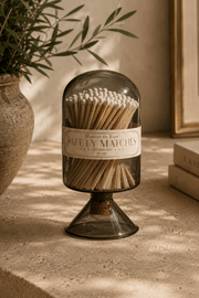 Glass Match Cloche in smoky brown glass, filled with long wooden matches and topped with a rounded dome lid