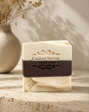 Goat's Milk & Honey artisan soap bar with cream and dark brown layers, embossed lettering, and a handmade swirled finish