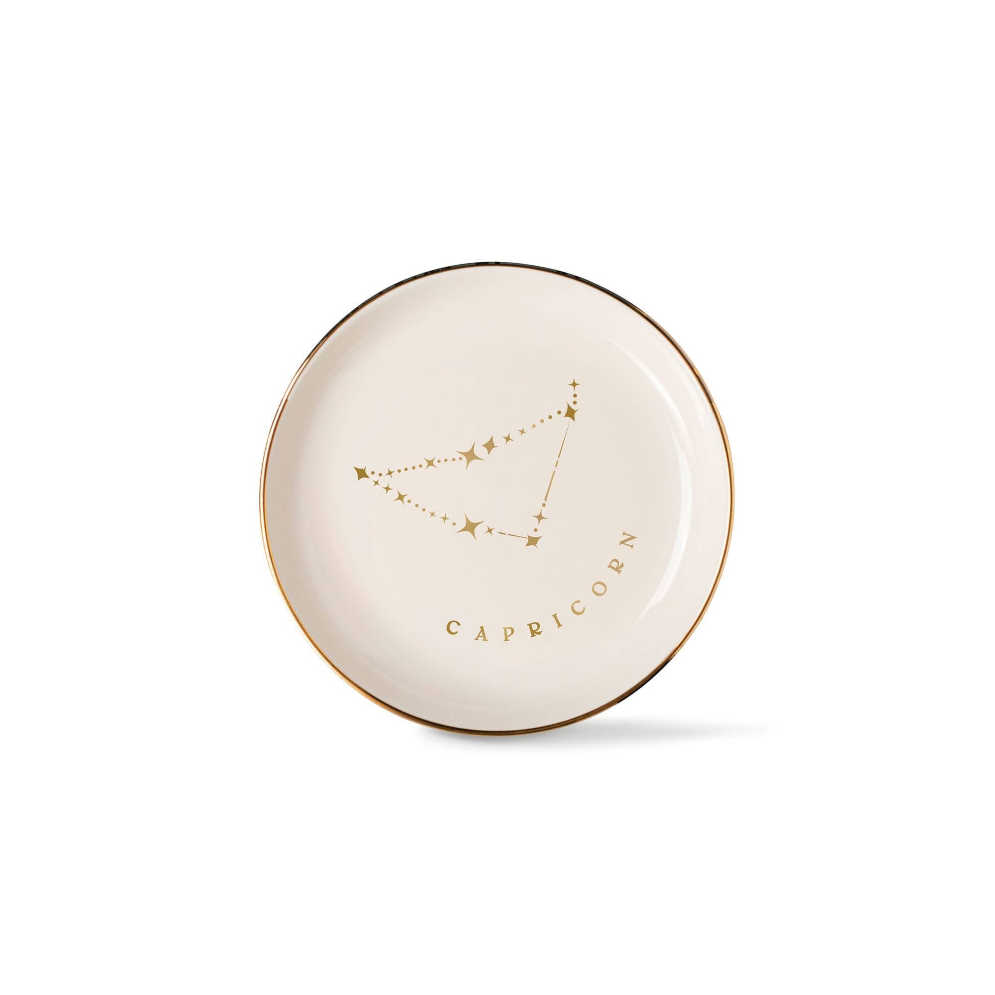 The Rooted Home Capricorn Zodiac Pedestal Tray in cream stoneware with metallic gold constellation and rim detail.