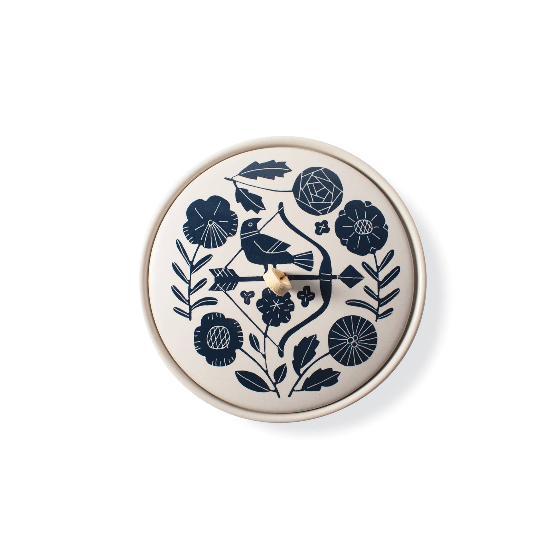 The Rooted Home round ceramic trinket box with a cream matte finish, navy floral pattern, and faux suede loop handle.