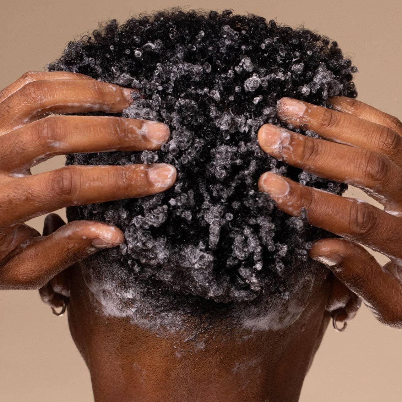 The Rooted Home Kitsch shampoo lathered into short curly hair for a deep clean and nourishing hair care treatment