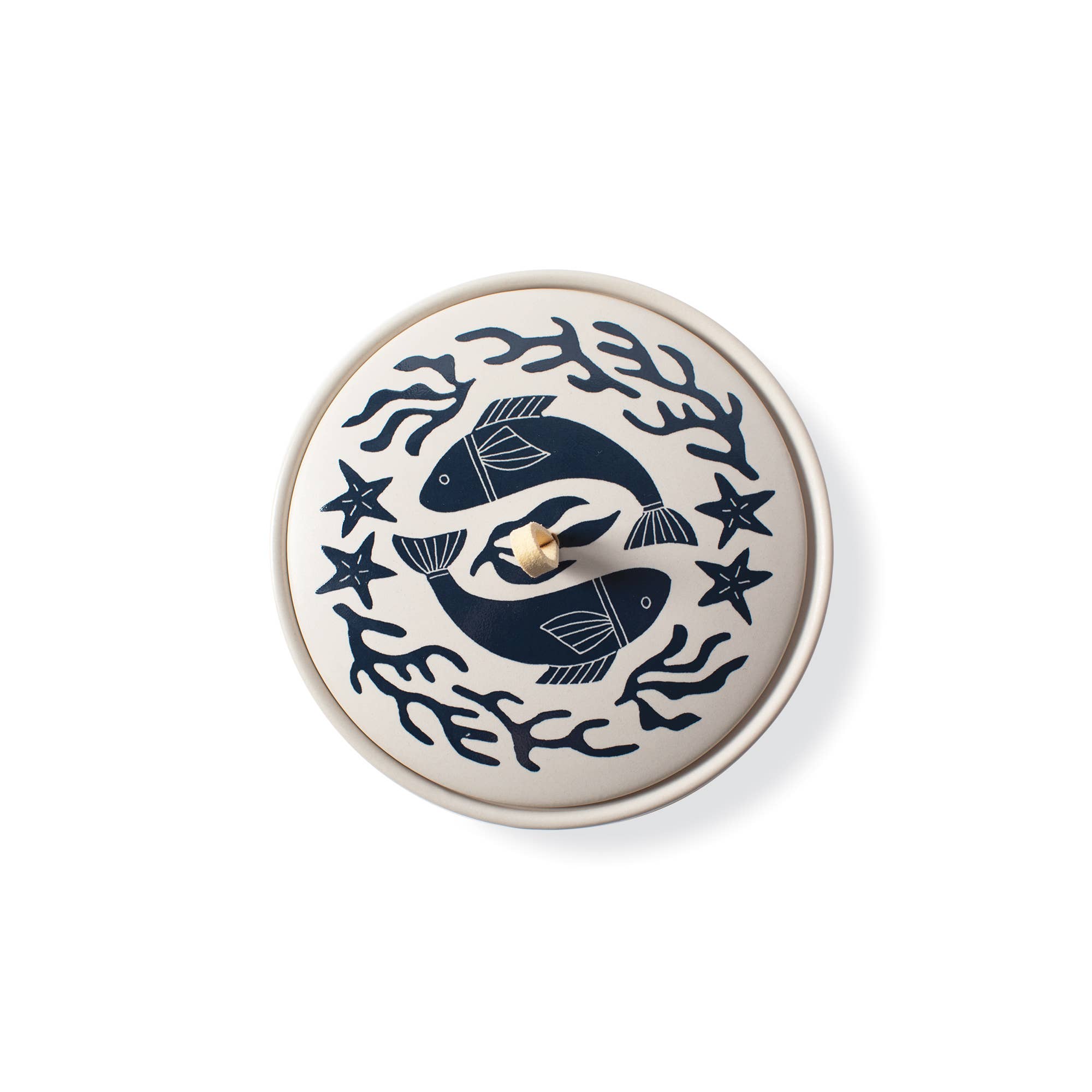 The Rooted Home Pisces zodiac ceramic trinket box with a matte cream finish, navy blue fish design, and suede loop.