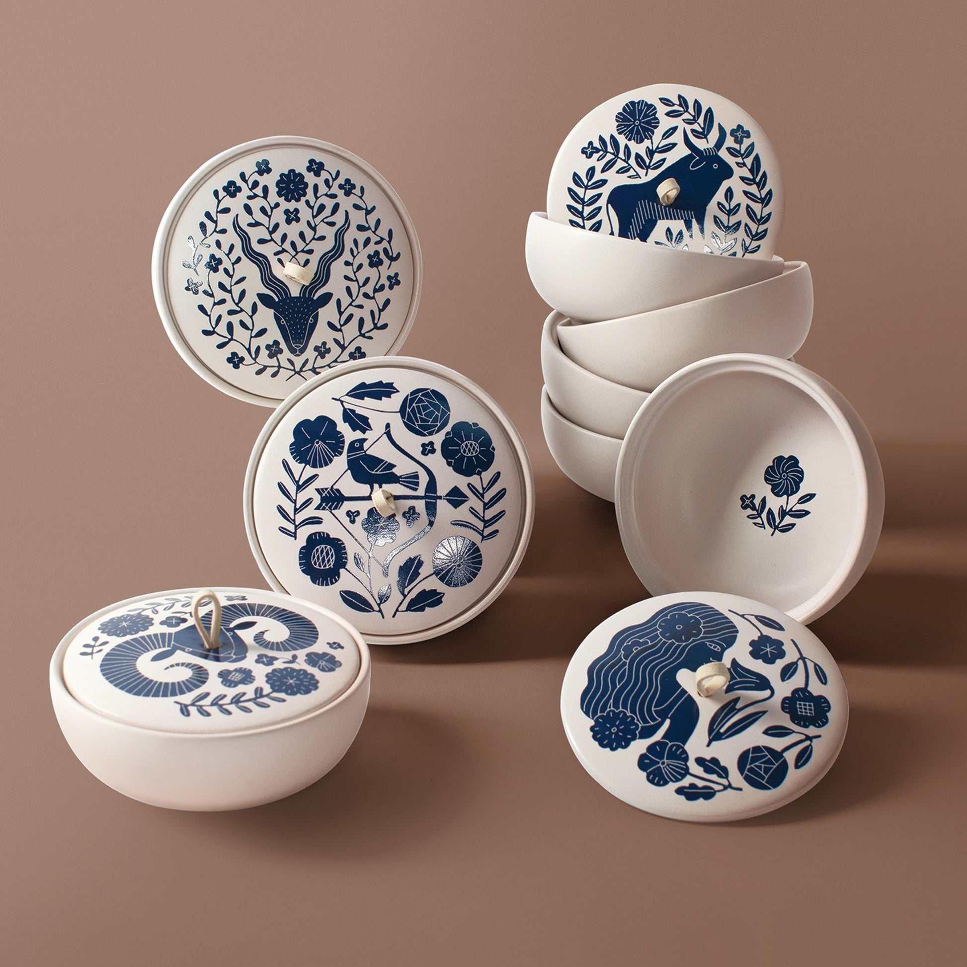 The Rooted Home ceramic zodiac trinket boxes with blue floral patterns, matte finish, and faux suede loop handles.