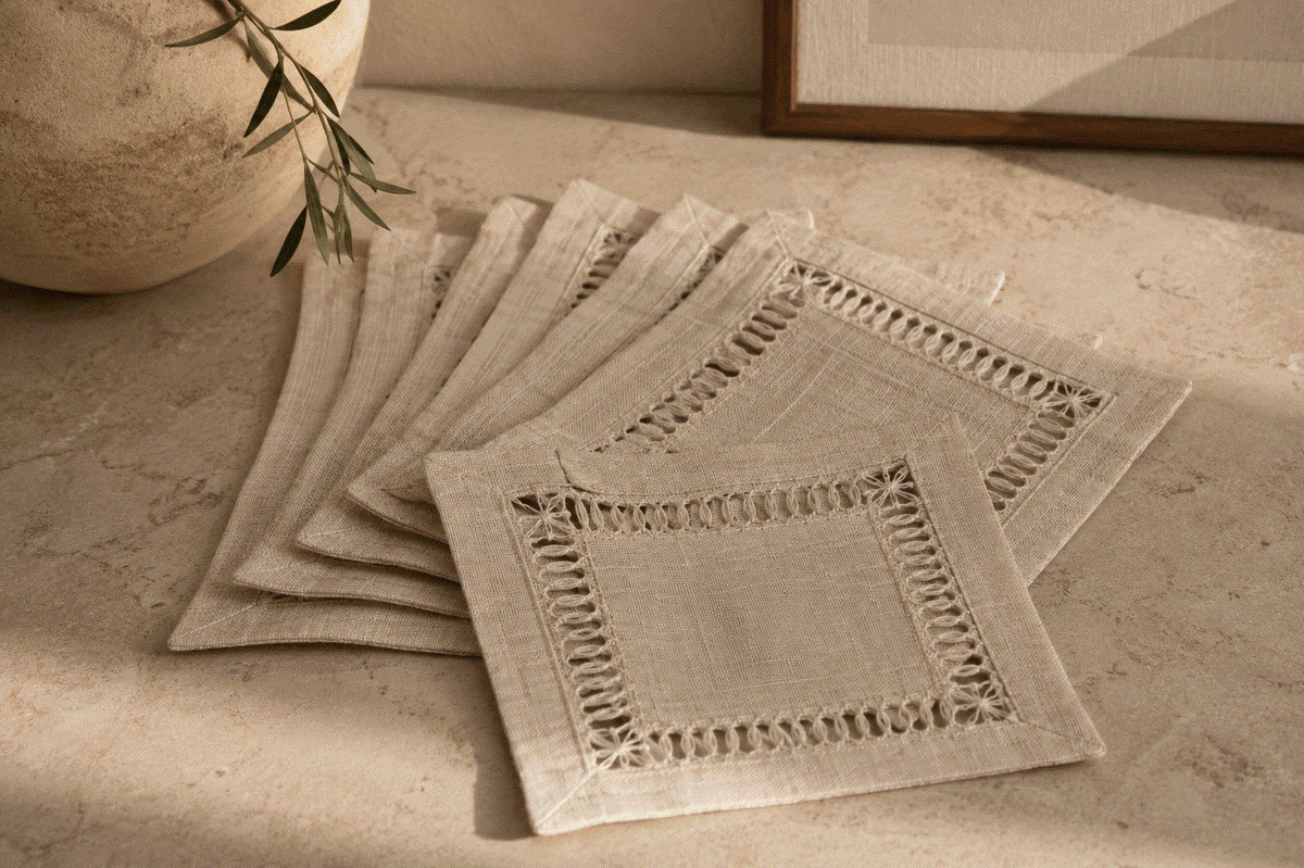 Toscana Hemstitched Cocktail Napkin Set in natural beige woven fabric, with square shapes and open hemstitched borders